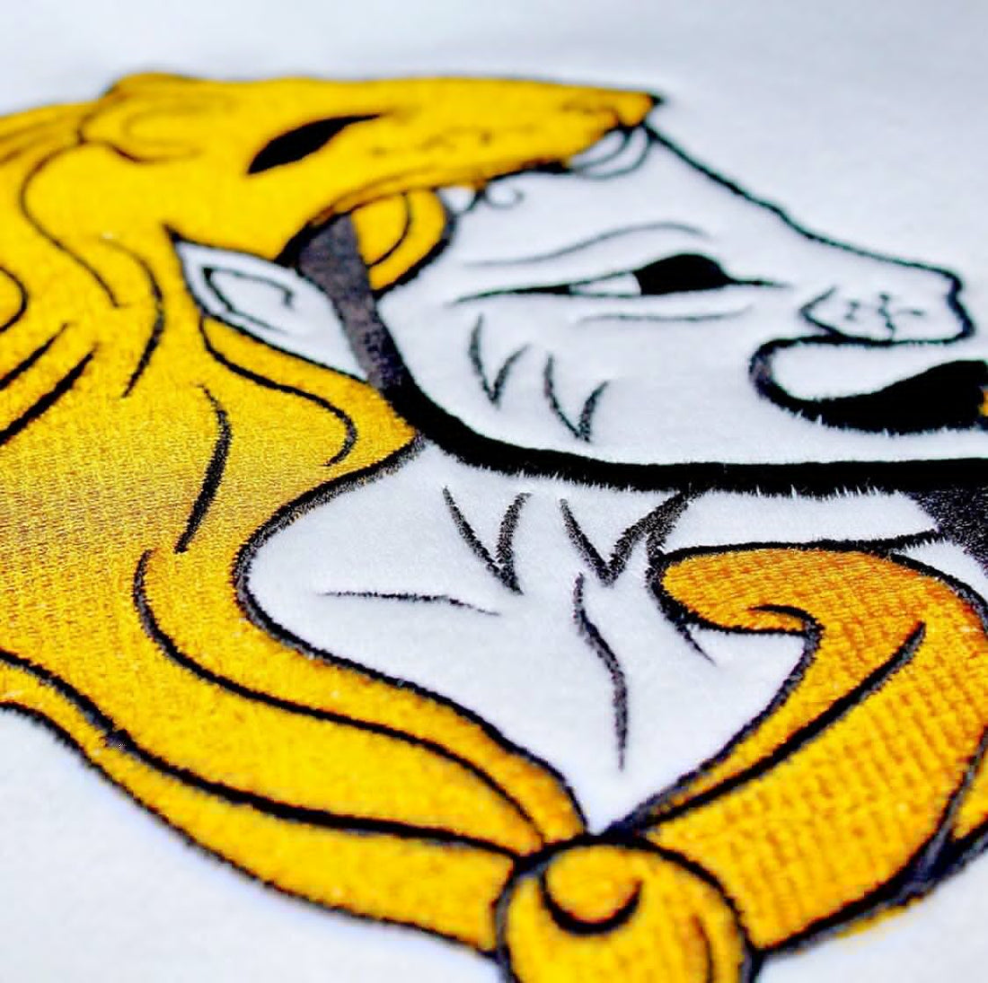Close up of golden lion embroidery symbolizing leadership, craftsmanship, and luxury representing R10's philosophy "Born to Lead, Built to Last."