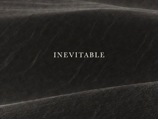 Minimalist black editorial image with subtle texture and the word “Inevitable,” representing R10’s philosophy of quiet luxury, discipline, and enduring presence.