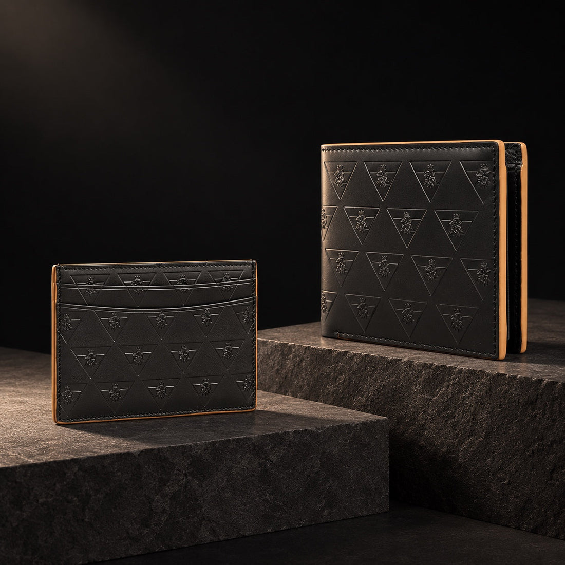 Black R10 cardholder and wallet displayed on separate charcoal stone planes.