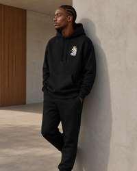 Model wearing the Leão Branco Motif Hoodie in a minimalist architectural setting that emphasizes timeless everyday design.