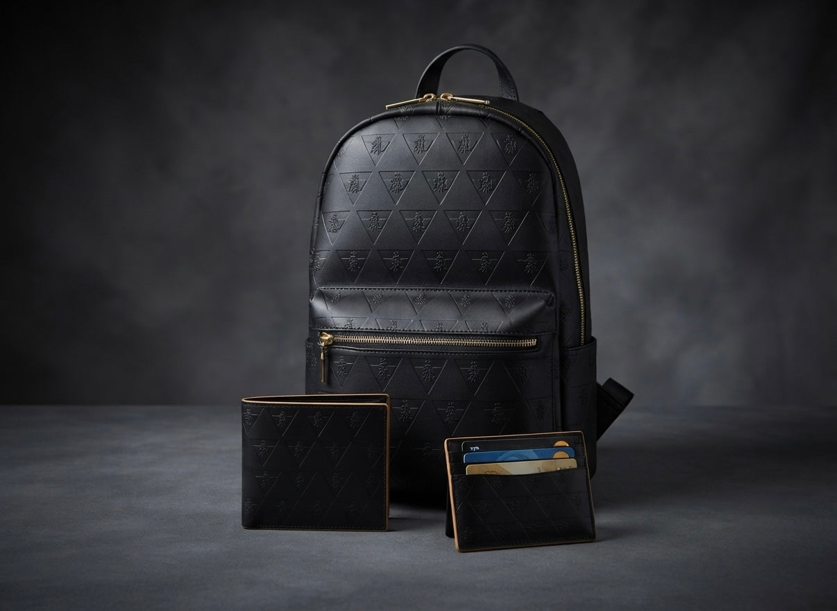 Premium black leather backpack and coordinated leather carry objects arranged against a dark background to represent the R10 Leather Division system for controlled daily carry.
