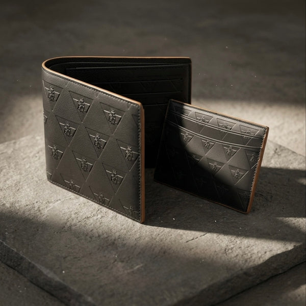 Premium leather cardholder and wallet arranged on a stone surface representing intentional everyday carry.