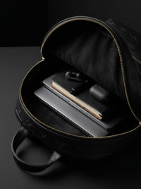 Open leather backpack showing organized space for daily essentials and controlled carry
