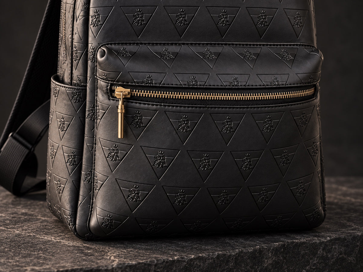 Detail of the R10 backpack’s front-pocket zipper, gold-tone hardware, stitching, and embossed leather.