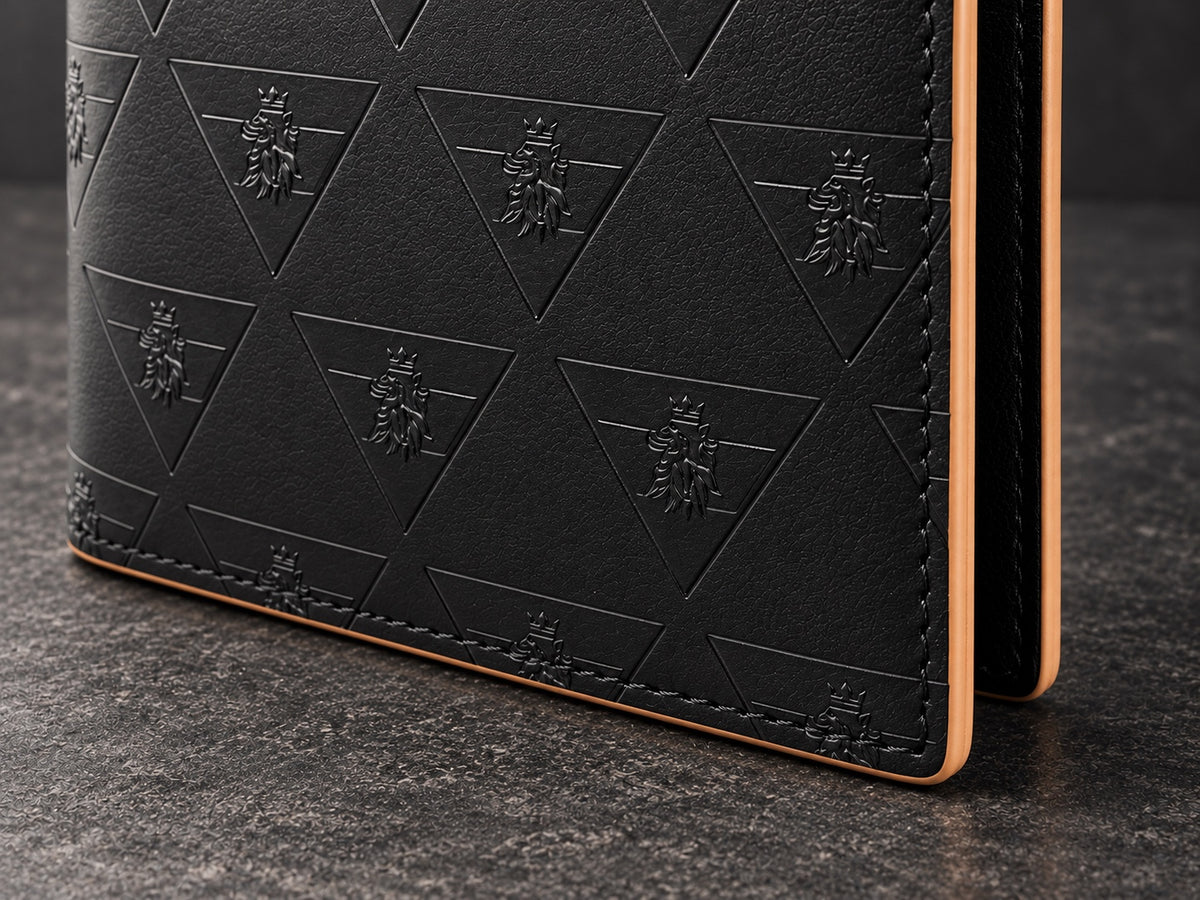 Close view of the R10 wallet’s exterior corner showing leather texture, embossed motifs, perimeter stitching, and finished edge.