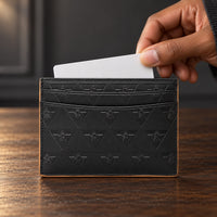 A hand retrieves a plain card from the black R10 cardholder above a wooden worktable.