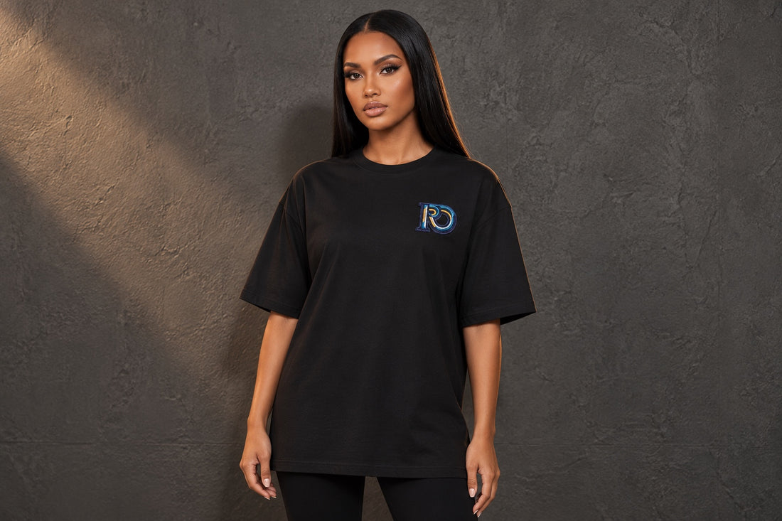 Model wearing a black R10 Monogram tee with its chest embroidery and full hem visible.