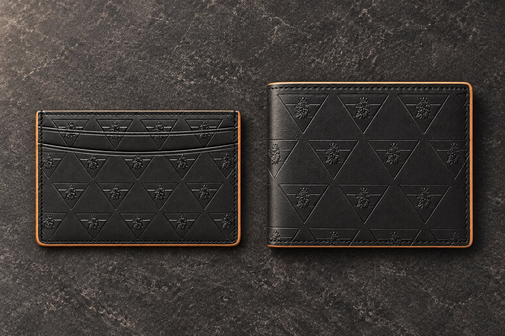 Overhead view of the black R10 cardholder and closed wallet side by side on charcoal stone.
