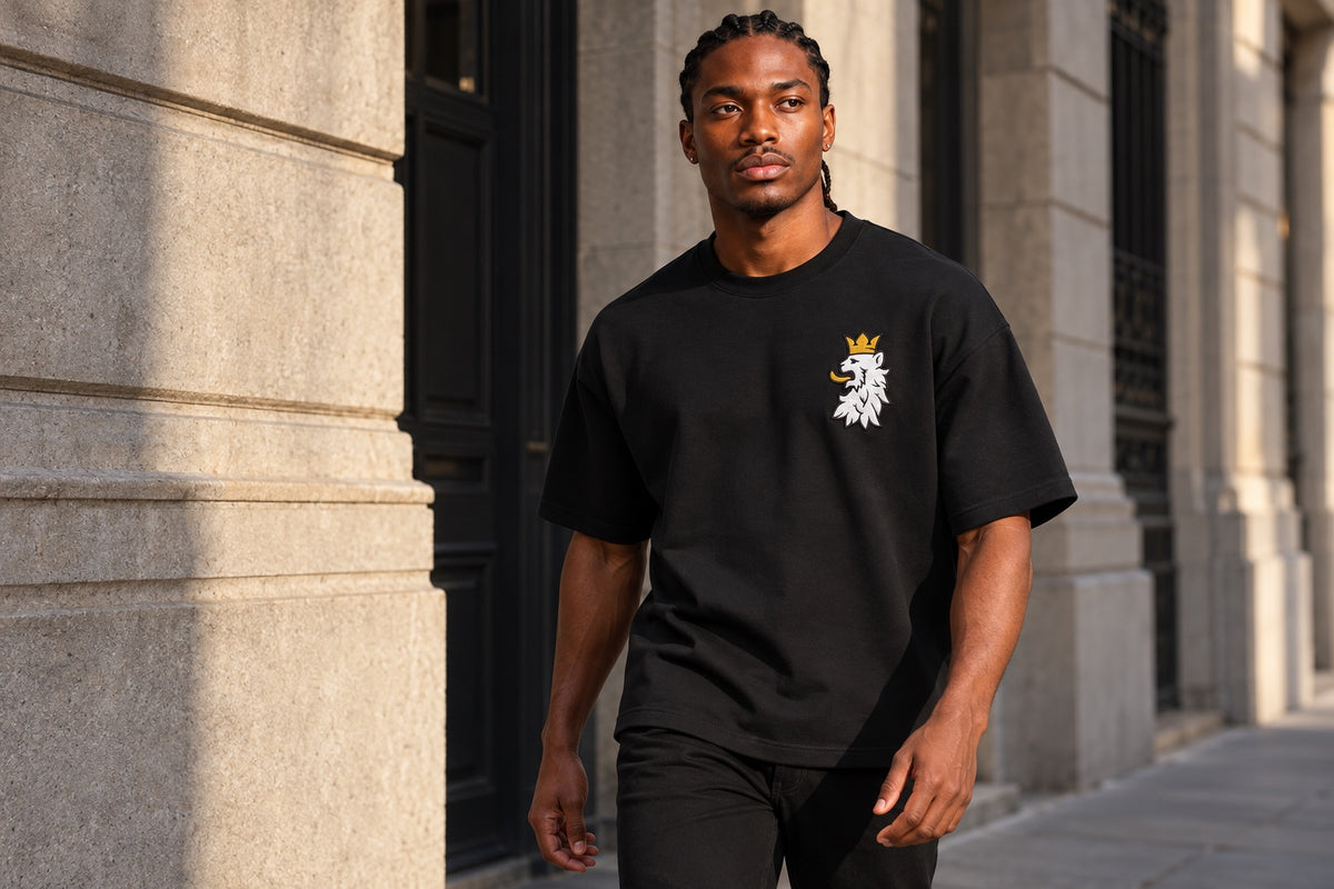 Model wearing the black Leão Branco Motif Tee, with the sleeves and hem visible.