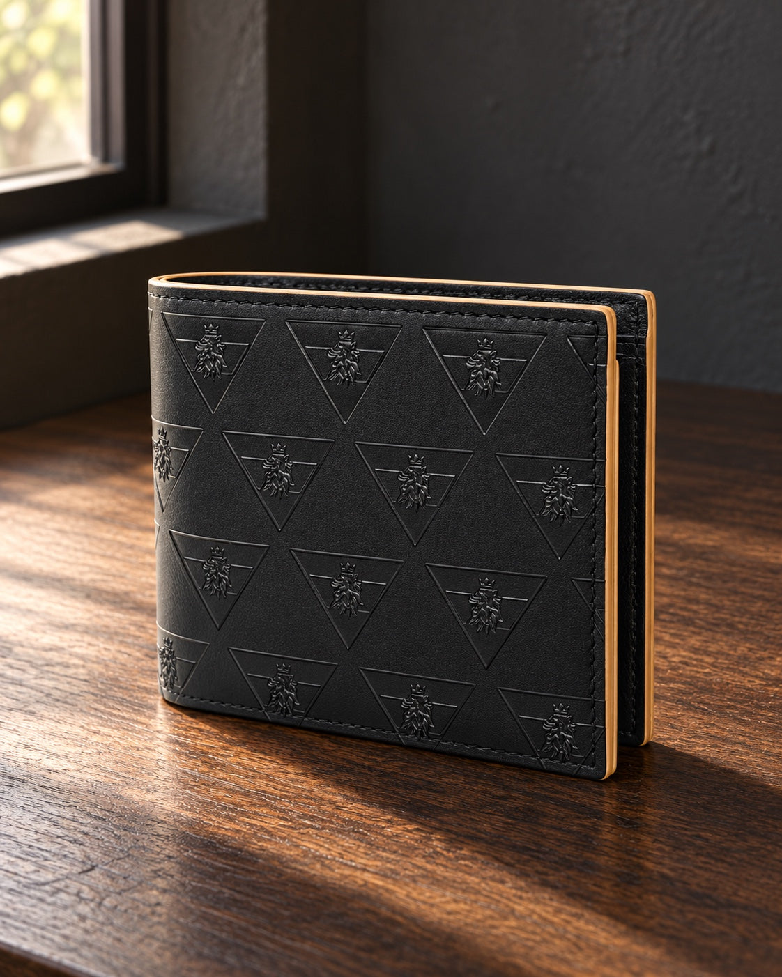 The black R10 Leão Branco wallet resting on a wooden desk beside a shaded window.